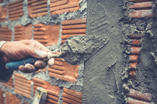 AlbaÃ±ilerÃ­a trabajador de la construcciÃ³n construyendo una pared de ladrillos.