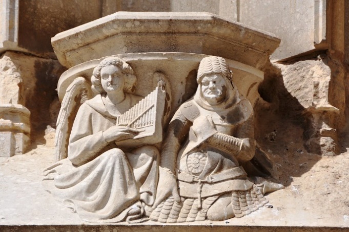 Girona. Cathedral church of Saint Mary. Portal of the apostles. 1370-1382. Corbel. Angel and soldier: the music and the war.